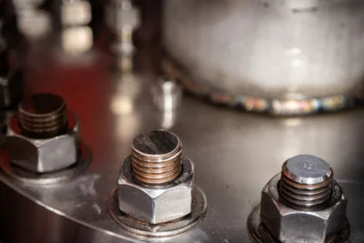 Big bolts with nuts on them hold some sort of metal hardware together