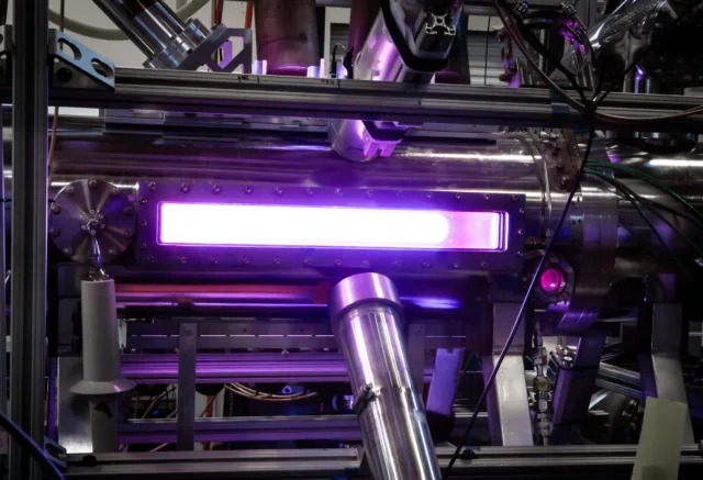Pink-purple light glows from a Zap Energy fusion device