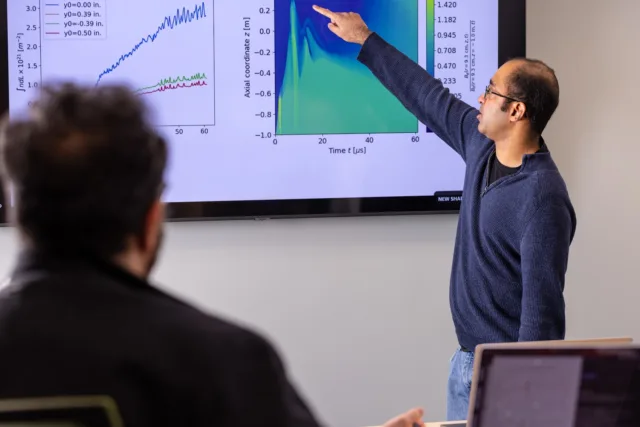 A scientist named Iman Datta stands before a Zap Energy fusion device.