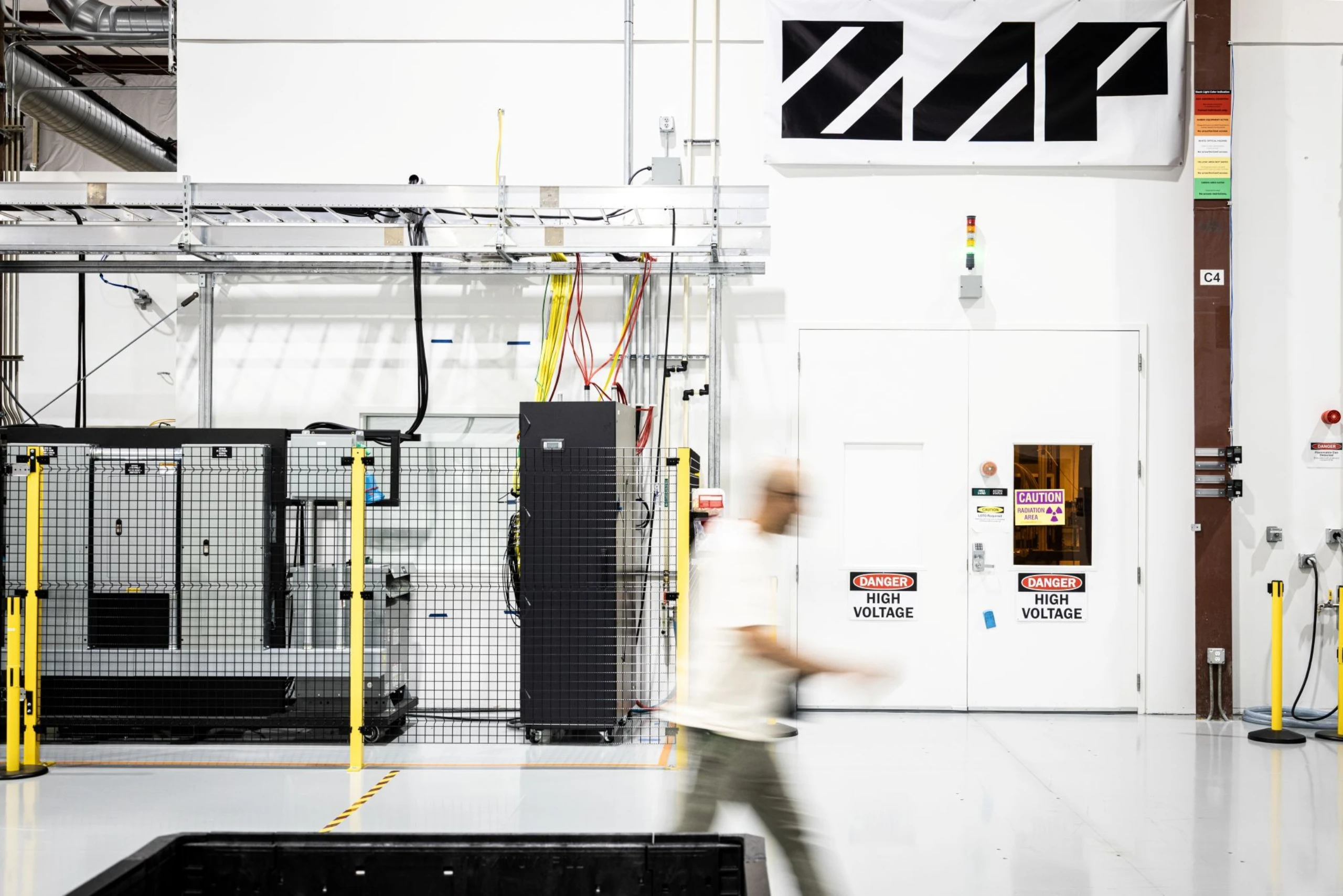 A facility with the zap logo on it and a person walking by who has motion blur
